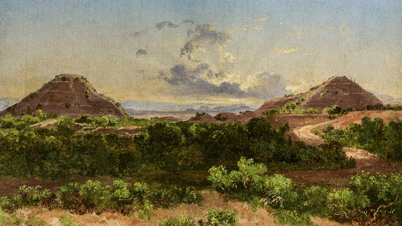 Two pyramids in the background with clouds between them. Shrubbery in the foreground