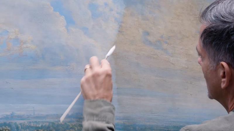 Larry removing the varnish from the painting with a swab